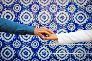 hands of a loving couple hold together in a Talavera background in Latin america mexico city