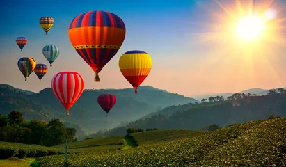 Schilderijen op glas Heteluchtballon boven hoge berg bij zonsopgang of zonsondergang. © applezoomzoom