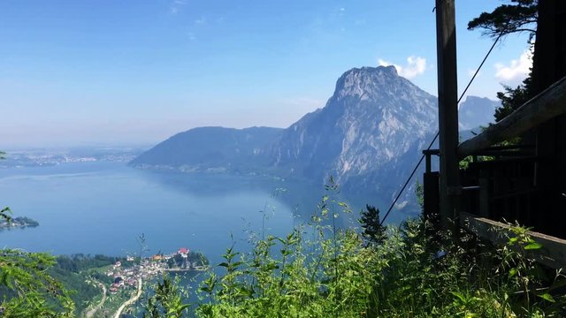 Gimbal shot through a fence revealing the Traunsee from above.