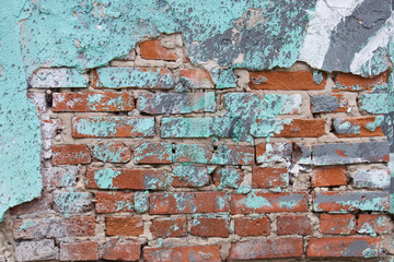 old red brick wall with cracks and old turquoise paint