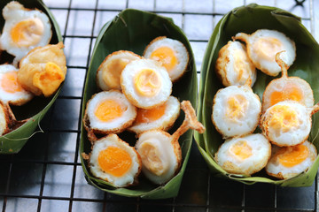 Fried quail eggs (Khanom Krok Khai Nok Krata in Thai language) in Thai style recipe on banana leaf...