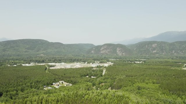 An aerial, cinematic, moving view of the outskirts of town, shot in Terrace, B.C. Canada during the summer months on a sunny day.