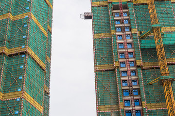 High-rise building guardrail scaffolding nets and tower cranes being built in Chinese cities	