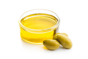 Green olives and olive oil in glass bowl.