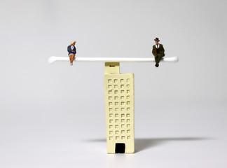 Miniature people sitting on top of a miniature building.