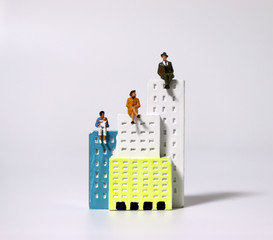 Miniature people sitting on top of a miniature building.