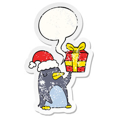 cartoon penguin and christmas present and speech bubble distressed sticker