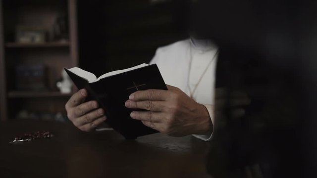 Pope reads the Bible in his office. Slow motion 100 fps