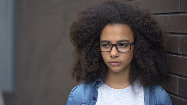 Arrogant female teenager insulting afro-american classmate, school bullying