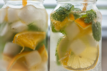 non-alcoholic summer drink with lemon, orange ice, on a light background, high key 