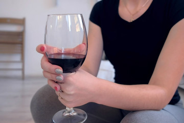 Woman with a glass of red wine in her hands, hands close-up