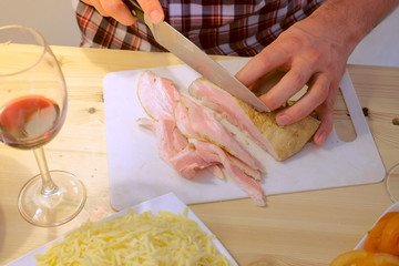 Man cuts smoked brisket, hands close-up. Prepares the ingredients for pizza