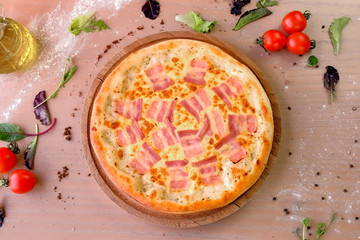 Pizza with bacon and cheese on wooden board on the table. Close-up view