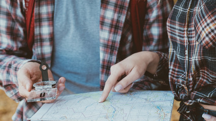 Wanderlust and adventures. Cropped shot of travelers using compass and map to explore country. © golubovy