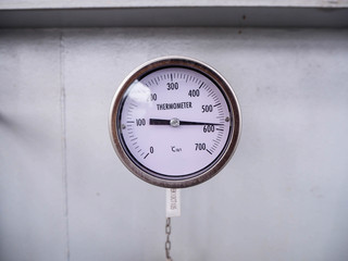 Temperature gauge for measuring instrument close up in industry zone at power plant.