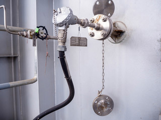 Temperature transmitter for measuring instrument close up in industry zone at power plant.