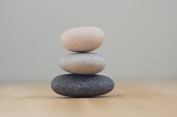 Obraz na płótnie Canvas Harmony and balance, cairns, simple poise pebbles on wooden light white gray background, simplicity rock zen sculpture