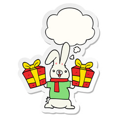 cartoon rabbit with christmas presents and thought bubble as a printed sticker