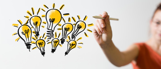 Obraz premium holding illuminated light bulb, idea, innovation and inspiration concept.