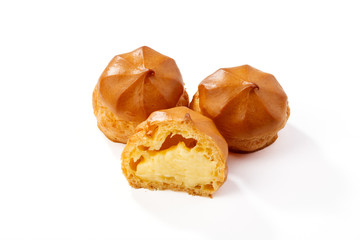 Profiterole or eclair, homemade sweets, close-up, isolated on white background.
