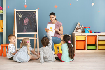 Cute little children learning letters in kindergarten