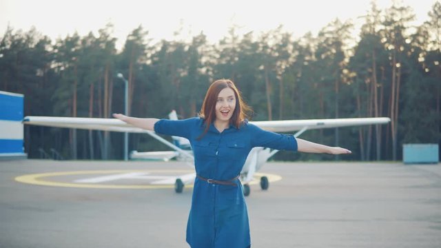 Portrait of a young woman on the background of a private light aircraft