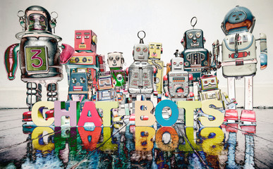 the word  CHAT BOTS  with wooden letters and retro toy robots  on an old wooden floor