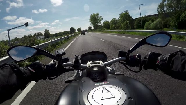 Driving the motorbike from the rider's perspective on a main road with little traffic