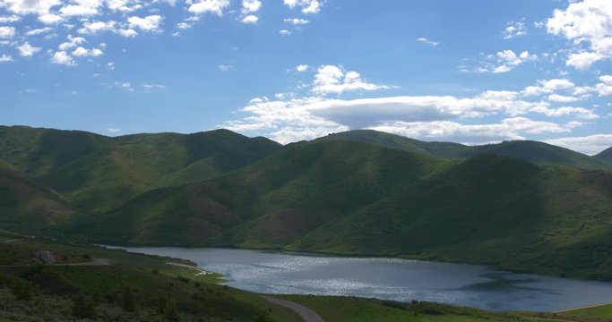 A Wide Shot of Strawberry Reservoir in Utah. Rich blue skies and puffy clouds above the calm reservoir.