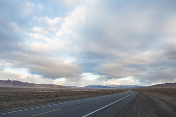 Road ahead with storm clouds above mountain