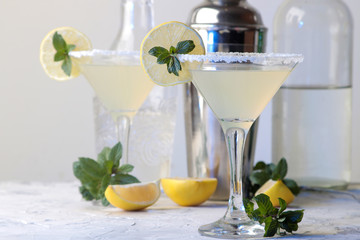 Margarita cocktail, Alcoholic drink, Margarita cocktail with lemon and mint on a bright table. bar. bar supplies and accessories