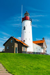 Fototapeta na wymiar lighthouse on green hill along the IJsselmeer in Urk, The Netherlands