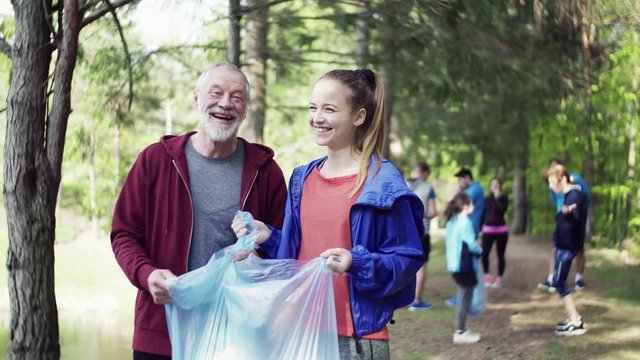 Group of fit people picking up litter in nature, a plogging concept.