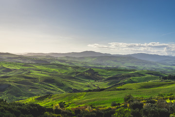 Obraz premium Vallata verde e collinare al tramonto