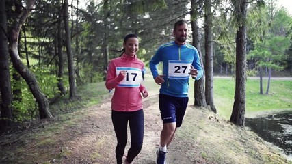 Large group of multi generation people running a race competition in nature.