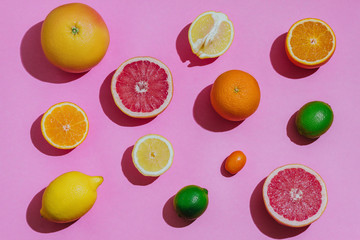 Citrus fruits fresh cutted on a pastel pink background closeup separately top view