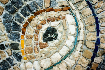 A fragment of the wall of small colored stones. The texture of the stone. Beautiful natural colorful background. Close up