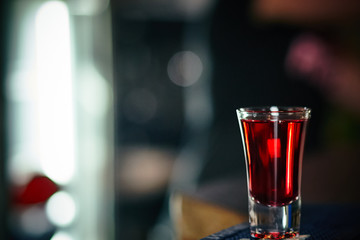 shot with a red drink on the background of a bar