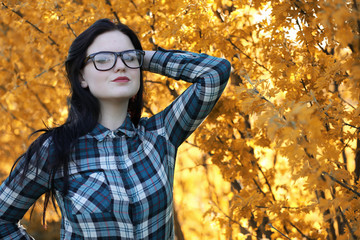 A young girl is traveling around the city hitchhiking. A beautiful young girl went on vacation. A female student in a cowboy hat on the road in autumn.