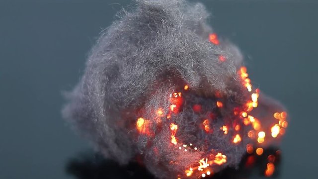 Macro shot of steel wool clots burning, with fire that propagates rapidly to all parts