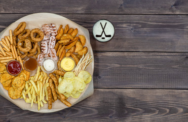 Diverse snacks with beer on dark wooden background. Top view, Empty space for text