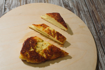 Delicious, fried and healthy Halloumi cheese on a light wooden tray on a beautiful wooden background