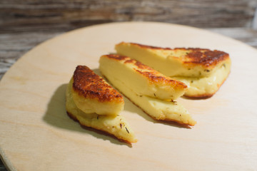 Delicious, fried and healthy Halloumi cheese on a light wooden tray on a beautiful wooden background