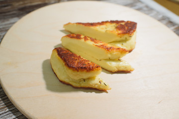 Delicious, fried and healthy Halloumi cheese on a light wooden tray on a beautiful wooden background