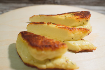 Delicious, fried and healthy Halloumi cheese on a light wooden tray on a beautiful wooden background