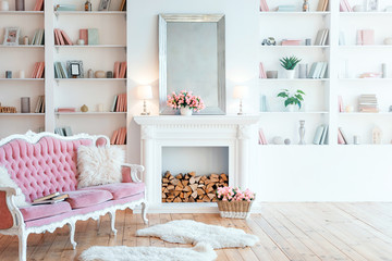 Modern light interior with fireplace, spring flowers and cozy pink sofa