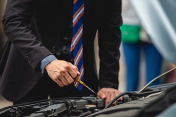Businessmen help businesswomen check and repair broken cars