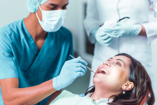 Dentist clening the teeth of a pacient in the dentistry