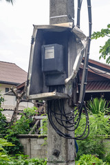 Broken electric meter box on pole . denger concept.