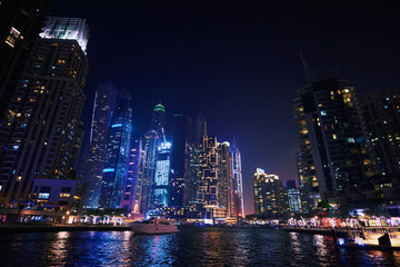 Dubai Marina at night with colorful touristic boats